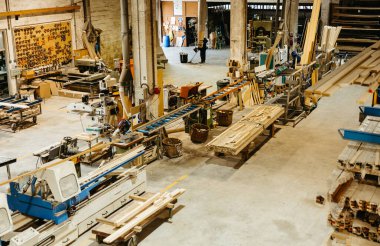 Aletler, makineler ve ahşap tahtalar olan bir metal marangozluk atölyesine genel bakış