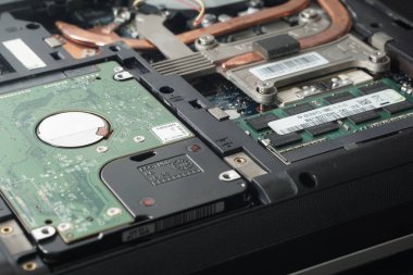 Açık bir dizüstü bilgisayarın geniş açılı görüntüsü Hard Disk Sürücüsü (HDD) ve RAM yuvalarının yerini gösteriyor. Depolama güncelleme yazıları veya DIY bilgisayar onarımı için ideal illüstrasyon.