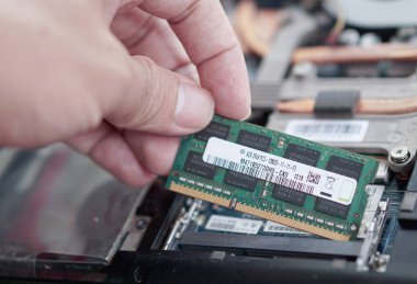 Bilgisayar tamiri sırasında DDR3 SODIMM RAM çubuğunu ana kart yuvası pimleriyle aynı hizaya getirmenin tam zamanı. Bağlantı arayüzüne odaklan.