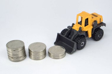 Altın Para Yığını Karşısındaki Sarı Oyuncak Yükleyicisi Finansal Büyümeye Karşı