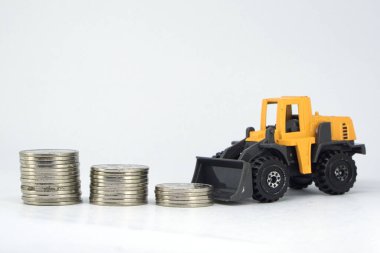 Altın Para Yığını Karşısındaki Sarı Oyuncak Yükleyicisi Finansal Büyümeye Karşı