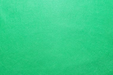 Dokumasız yeşil polipropilen spunbond kumaş dokusu, arkaplan ve doku olarak dokumasız parlak yeşil kumaşın yüzeyi