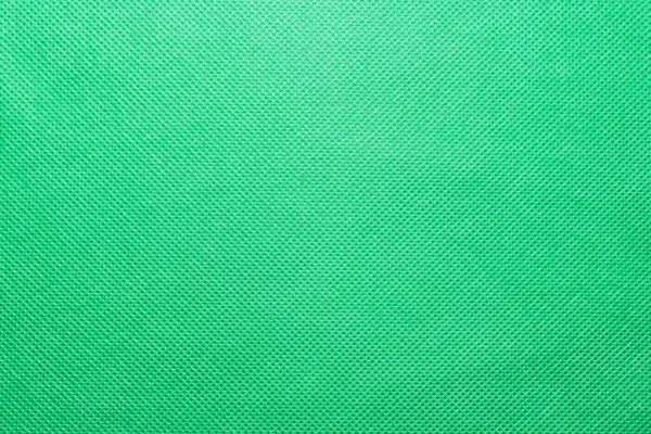 Dokumasız yeşil polipropilen spunbond kumaş dokusu, arkaplan ve doku olarak dokumasız parlak yeşil kumaşın yüzeyi