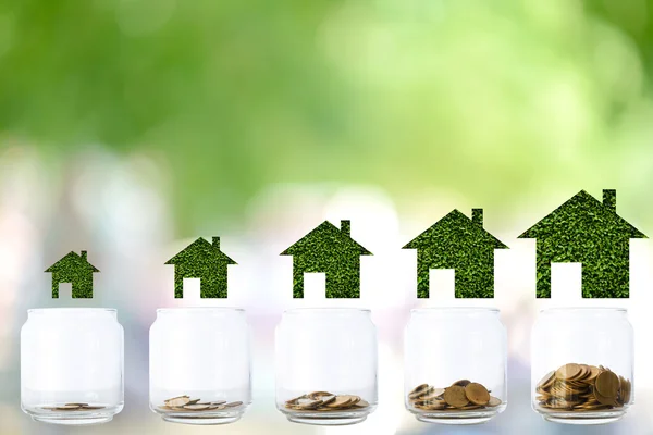 Kavramı farklı boyutta evler ve sikke yığını