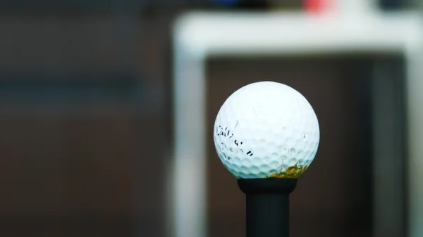 Cerca de la pelota en la camiseta retirado golfista tomando swing golpeando la pelota de golf de la camiseta en el campo de golf —  Fotos de Stock