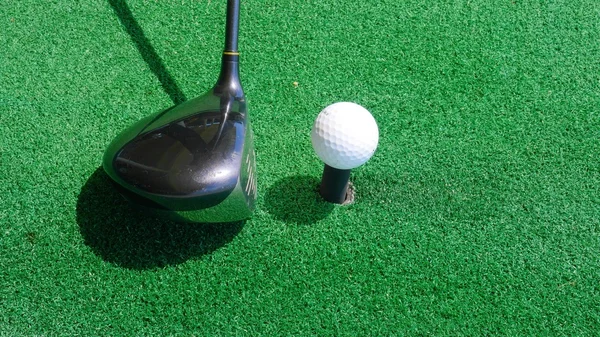 Close up ball on tee retired golfer taking swing hitting golf ball off tee on golf course — Stock Photo, Image