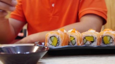 bir restoranda rulo suşi yemek