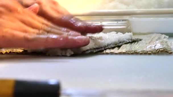Suši šéfkuchař připravuje lososa broskvový Futomaki Roll. Suši muž vaření losos, avokádo, broskev, krevety a mlíčí sushi rohlíky. Japonská kuchyně recepty. Profesionální kuchař s kuchyňské nástroje. — Stock video