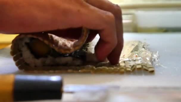 Suši šéfkuchař připravuje lososa broskvový Futomaki Roll. Suši muž vaření losos, avokádo, broskev, krevety a mlíčí sushi rohlíky. Japonská kuchyně recepty. Profesionální kuchař s kuchyňské nástroje. — Stock video