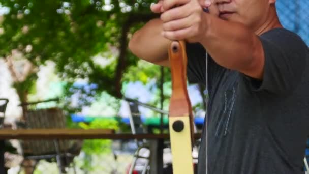 Bogenschütze hält seinen Bogen auf eine Zielscheibe — Stockvideo