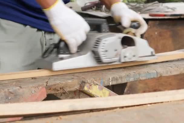 Werken timmerman in de werkplaats. Elektrische Planer. Behandeling van houten planken elektrische tool — Stockvideo