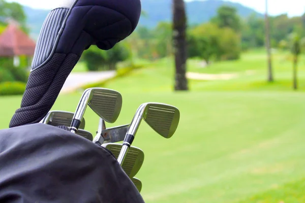 Conjunto de palos de golf sobre fondo de campo verde — Foto de Stock