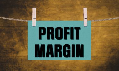 Kavramsal Kelime PROFIT MARGIN, dikdörtgen pankart asma, bir ip üzerinde ahşap mandallar ile kırpılmış, bulanık ahşap doku arka plan