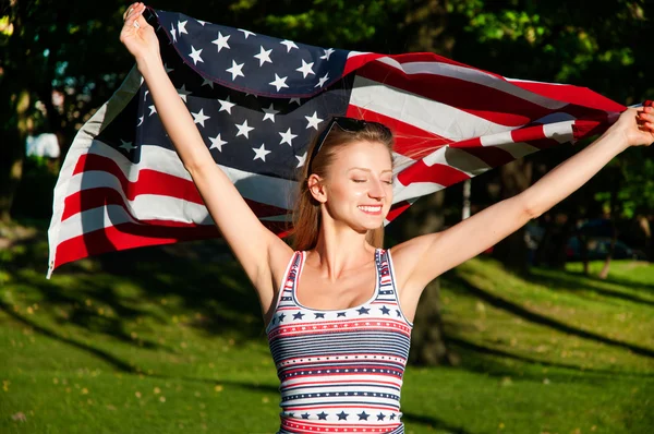 Young happy patriot woman holding the united states flag — Stock Photo, Image