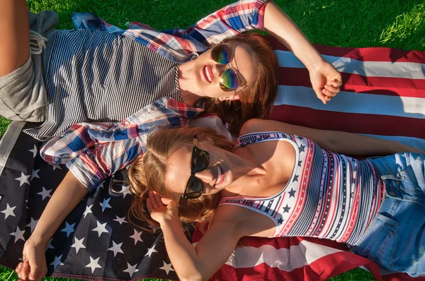 Young happy patriot women on the united states flag