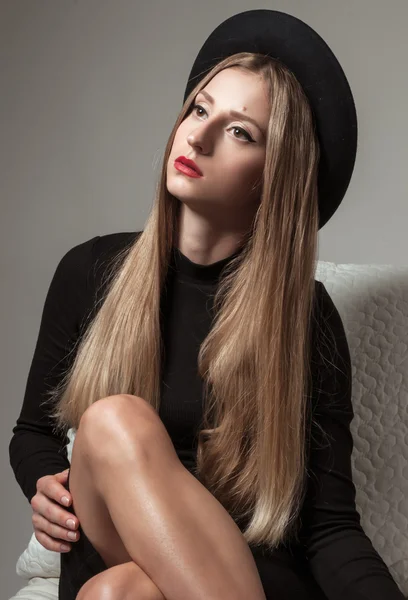 Красива стильна жінка з блондинкою довге волосся в чорній сукні і капелюсі — стокове фото
