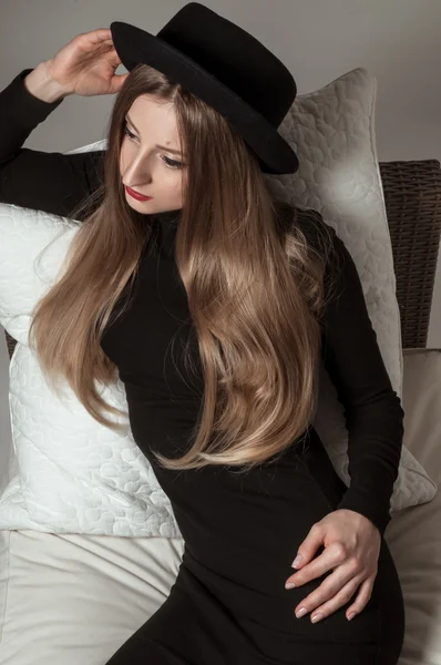 Hermosa mujer elegante con cabello largo rubio en vestido negro y sombrero — Foto de Stock