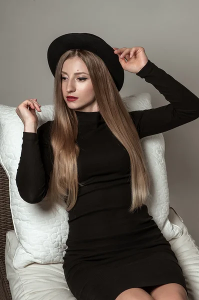 Hermosa mujer elegante con cabello largo rubio en vestido negro y sombrero — Foto de Stock