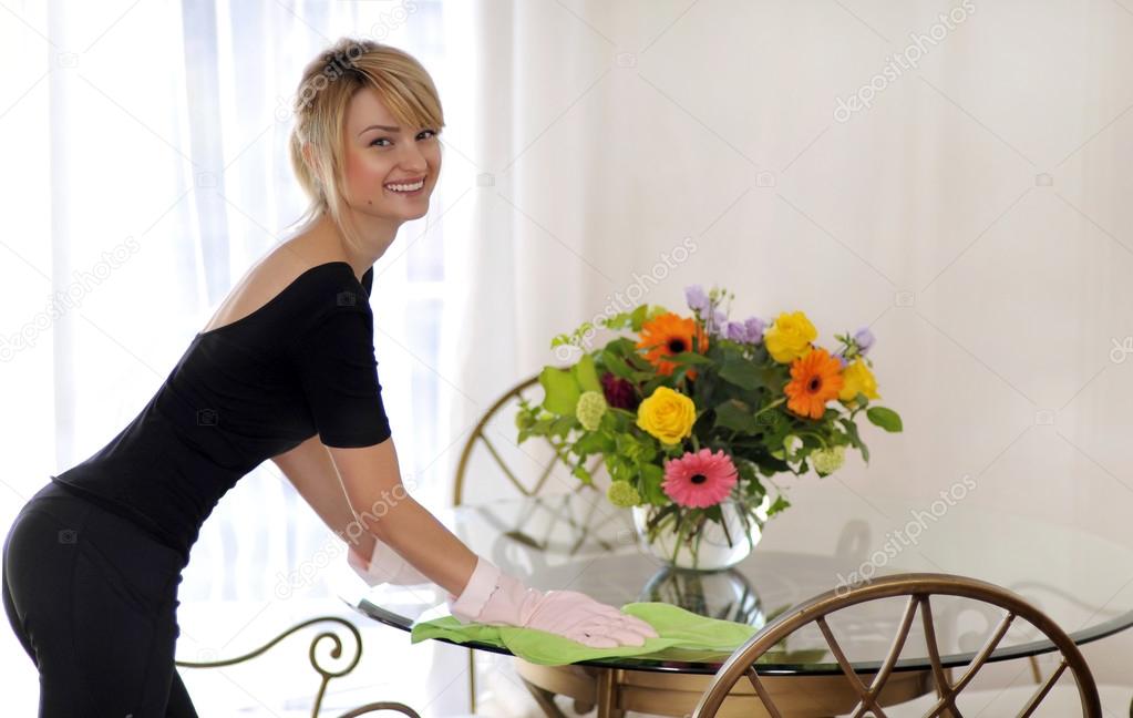 Woman maid cleaning glass desk with towel duster — Stock Photo