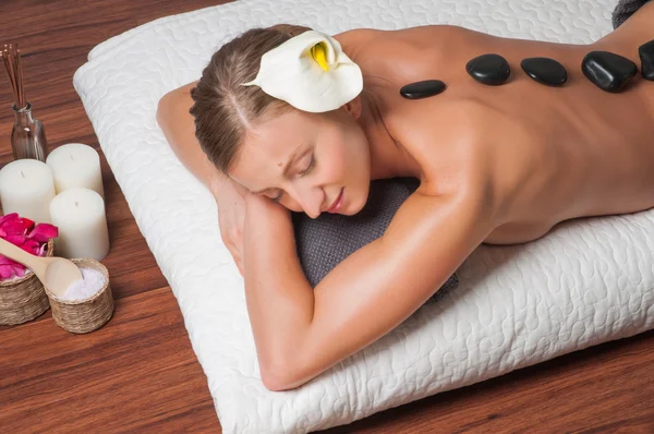 Masáž kameny. krásná žena se lávové kameny lázně-masáž ve wellness salonu. — Stock fotografie
