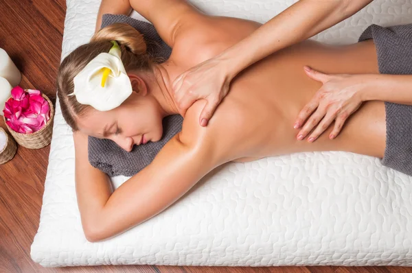 Masajista haciendo masaje en el cuerpo de la mujer en el salón de spa. — Foto de Stock