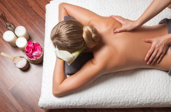 Masajista haciendo masaje en el cuerpo de la mujer en el salón de spa. — Foto de Stock