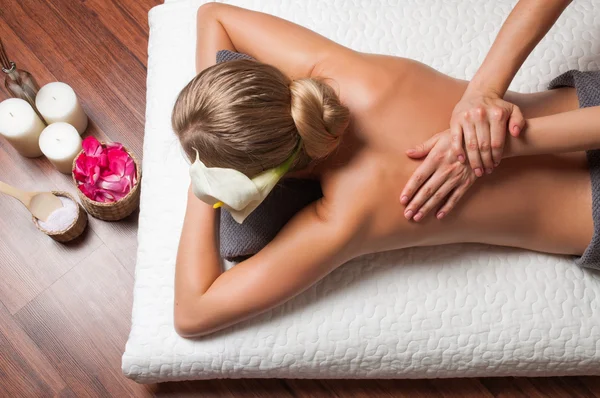 Masajista haciendo masaje en el cuerpo de la mujer en el salón de spa. — Foto de Stock