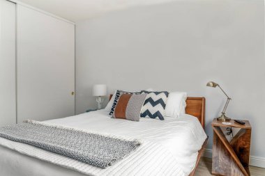 Modern çöl yatak odası içi ahşap çerçeveli yatak odası aksanlı yastıklar battaniye lambaları yan görüş