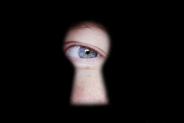 Eye looking at you through door keyhole — Stock Photo, Image