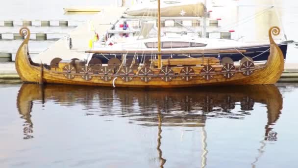 Antiguo vintage vikingo de madera militar guerreros escandinavos barco con escudos ondeando balanceo en el agua del puerto tranquilo que refleja como en el espejo — Vídeos de Stock