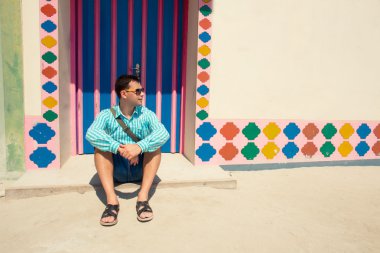 Mavi gömlek, sandalet giymiş genç esmer adam