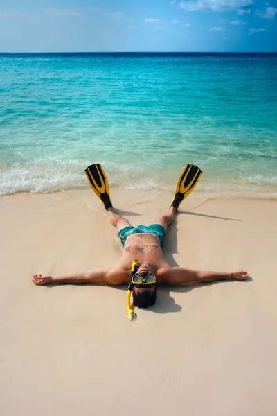 Man, relaxing in yellow black flippers fins and mask.