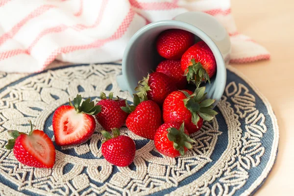 Fresh juicy strawberries in old rusty mug. Rustic wooden background with plaid patterned napkin and vintage towel. — Stock Photo, Image