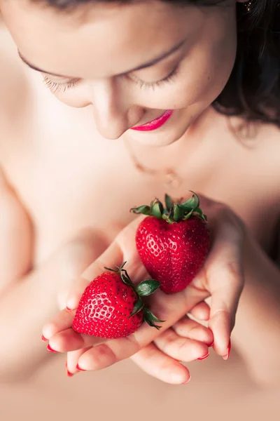 Фото соблазнительной женщины, держащей клубнику у губ лица, крупным планом портрет рыжеволосой чувственной женщины, кусающей ягоды — стоковое фото