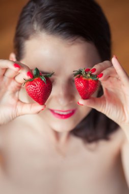 Baştan çıkarıcı kadın Holding yüz eyeys, berry ısırma closeup Kızıl saçlı şehvetli kadın portre çilek fotoğraf
