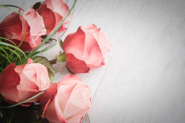 Un ramo de rosas sobre un fondo viejo de madera blanca. Estilo vintage . — Foto de Stock