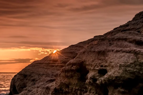 Красочные вспышки восхода солнца видны со скал пляжа — стоковое фото