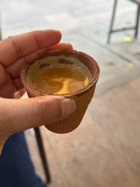 Kelebek olarak bilinen geleneksel kilden bir fincanda çay tutan bir kadın.