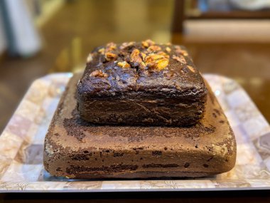 Çift katlı çikolatalı muzlu cevizli kek tepside duruyor.