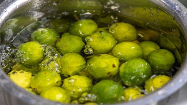 Limonlar onu yıkamak için su dolu bir kapta tutulur.