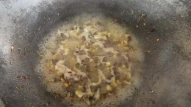 Sıcak zeytinyağının içinde küçük sarımsak ve kırmızı biber parçaları.