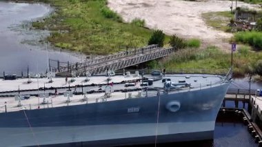 Low aerial view of the USS North Carolina BB-55 With Multiple Gun Turrets Docked at Wilmington Harbor, Military Vessel on Display