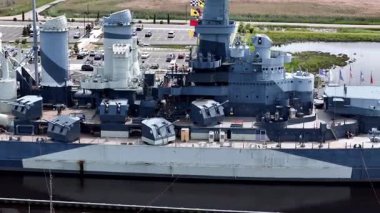 Low aerial view of the USS North Carolina BB-55 With Multiple Gun Turrets Docked at Wilmington Harbor, Military Vessel on Display