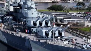 Low aerial view of the USS North Carolina BB-55 With Multiple Gun Turrets Docked at Wilmington Harbor, Military Vessel on Display
