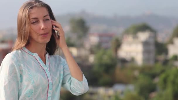 Feliz hermosa mujer que habla el teléfono, usando Smartphone, sonriendo, disfrutando de la vida. vale la pena a su pecho en el tejado de la gran ciudad al aire libre. Katmandú, Nepal — Vídeos de Stock