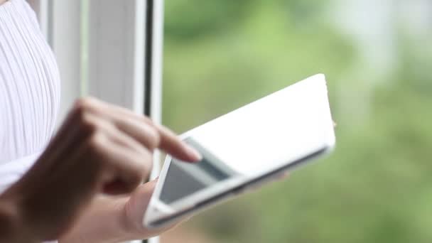 Frau mit Tablet-Computer-Touchscreen im Haus, Büro, Fenster. Weibliche Hände Nahaufnahme Eingabe von Text scrollen Laptop-Computer, verschwommener Hintergrund — Stockvideo