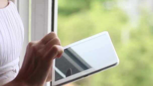 Frau mit Tablet-Computer-Touchscreen im Haus, Büro, Fenster. Weibliche Hände Nahaufnahme Eingabe von Text scrollen Laptop-Computer, verschwommener Hintergrund — Stockvideo