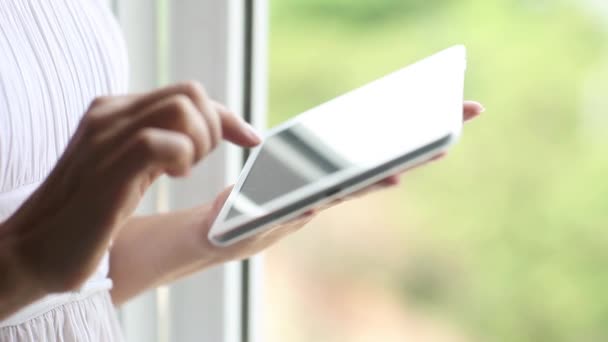 Kvinna med tablett dator pekskärm insidan hus, kontor, fönster. Kvinnliga händer närbild att skriva textrullning bärbar dator, suddig bakgrund — Stockvideo