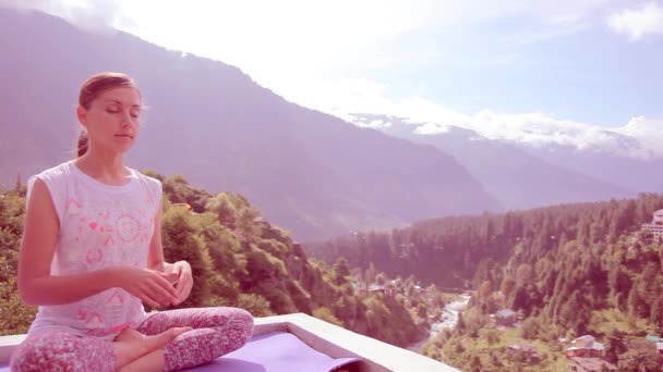 Prachtige jonge vrouw doen Yoga meditatie Lotus buiten vergadering Asana Mat dak huis hoge bergen, Sun. Toning, lavendel. De stralen van de zon, ochtend, zomer, Manali, India, Himalaya — Stockvideo