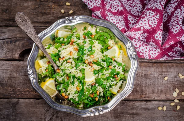Couscous salad with parsley and pine nuts in vintage bowl on wooden background. Selective focus. Toned image — Zdjęcie stockowe